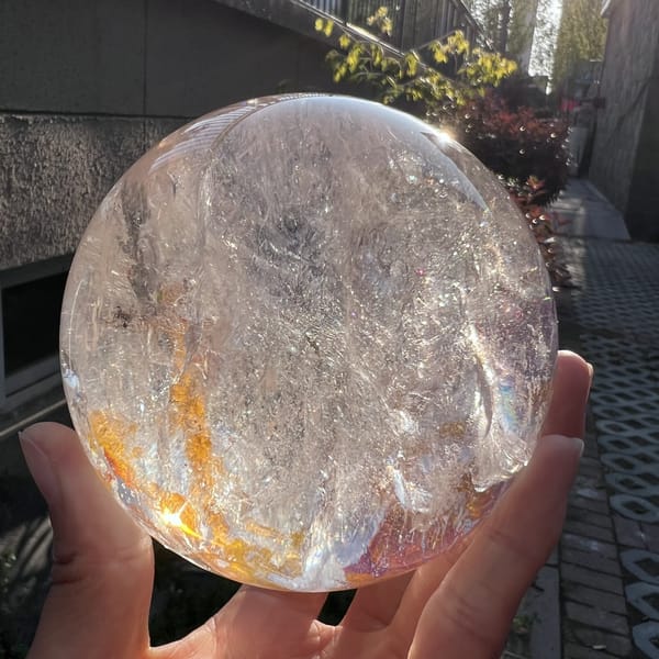 Paler face of the sphere showing veils and a small red patch at the edge
