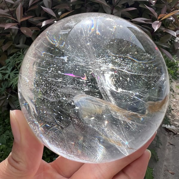 Pink rainbow flash above a wispy tan inclusion inside the sphere