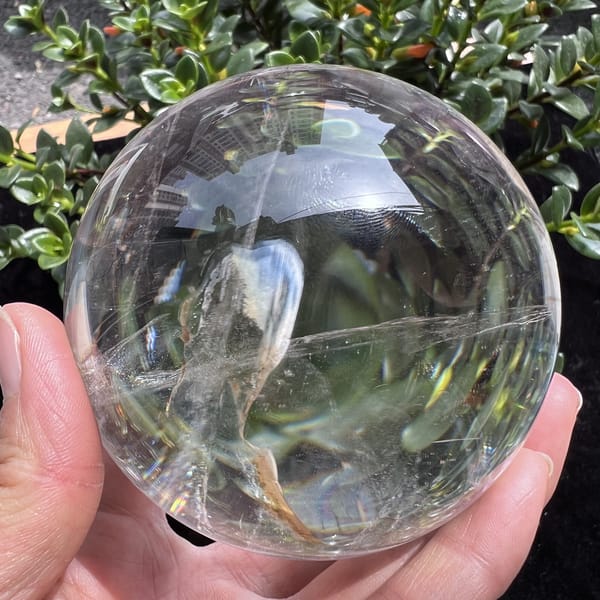 Sphere in sunlight with a pale yellow plume and needle sparkle