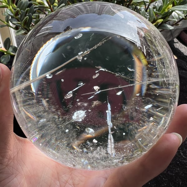 Diagonal tourmaline needle spanning the sphere with small flat inclusions