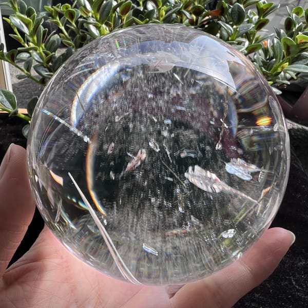 Long straight needle angled through the quartz with feathery veils nearby
