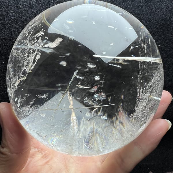 Feather inclusions near the base with needles slanting through the sphere