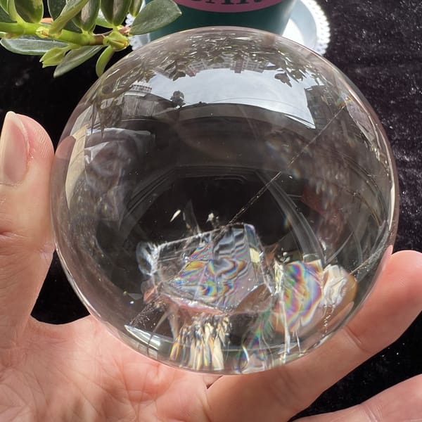 Rainbow-banded included crystal with fine hair-like strands around it