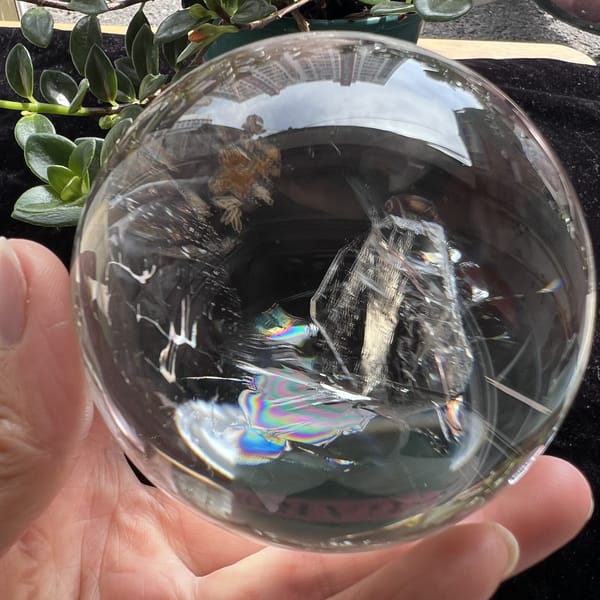 Side view of the included crystal as a tall prism with rainbow at its foot