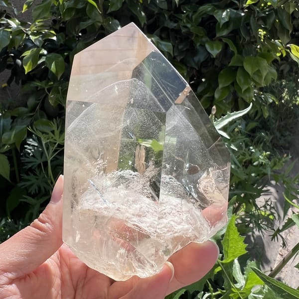 Three-quarter view of clear quartz faces over a white phantom mound