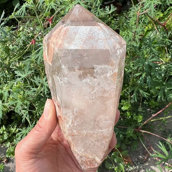 Peach-pink clear quartz tower with a flat-topped phantom shelf below the tip