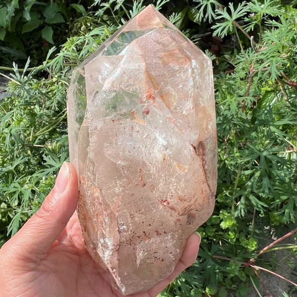 Face with soft green phantom patches among pink-dusted quartz