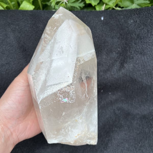 Lower face on black cloth with a small rainbow flash in the quartz