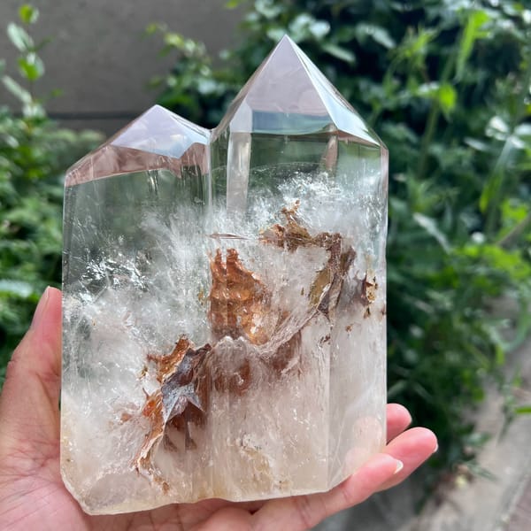 Rear face with a brown needle-like inclusion fanning through clear quartz