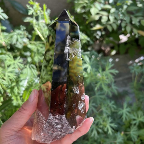 Dark smoky point with icy veils near the lower edge