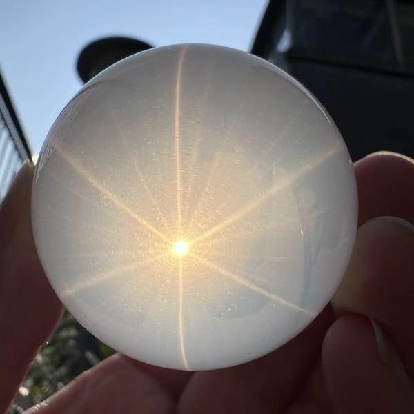 Six-ray star on the milky sphere against a dark building