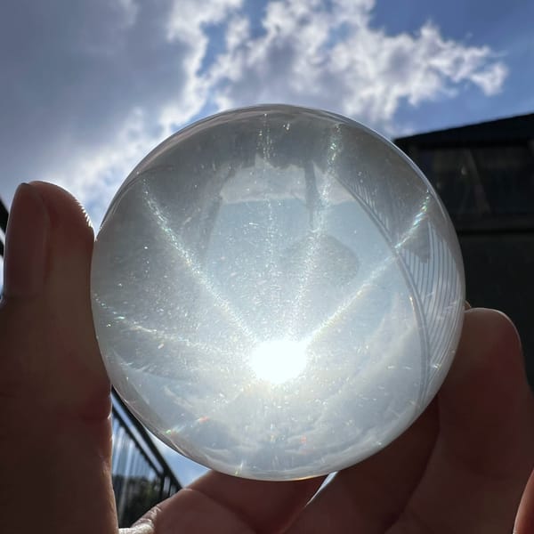 Milky quartz sphere against a cloudy sky, twelve-ray star glowing