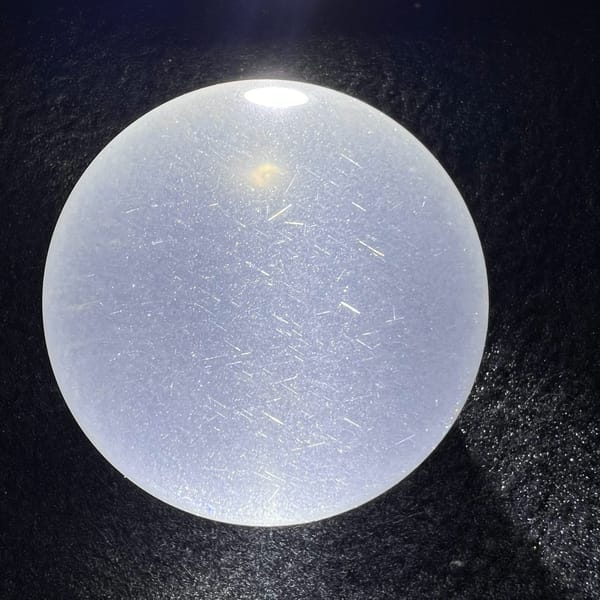 Sphere on dark cloth, starry field of tiny rutile needles