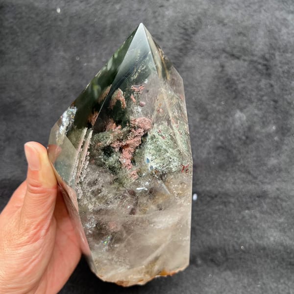 Tower held against grey cloth revealing pink and green flower phantoms inside