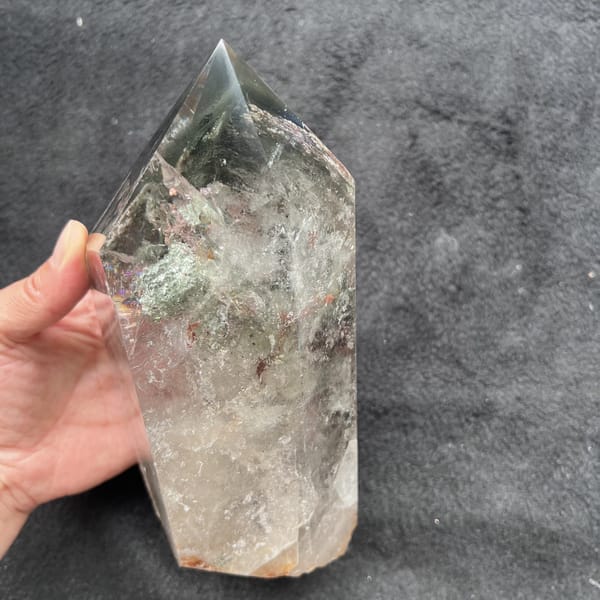 Tower tilted in the hand showing misty green layers and a clear lower body