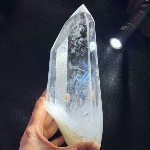 Tall quartz tower lit by a torch on black cloth revealing blue needle wisps