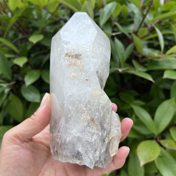 Narrow side with an attached smaller crystal and crust flecks