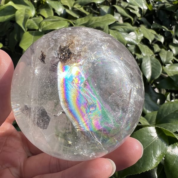 Rainbow and a brown inclusion cluster near the top of the sphere