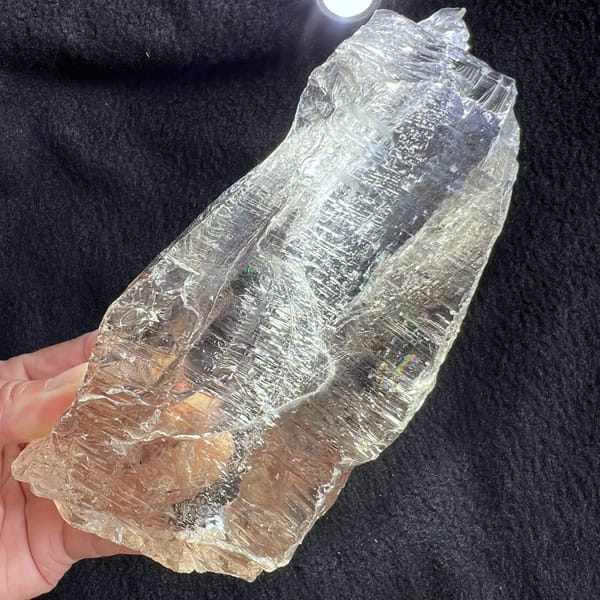 Crystal angled on dark fabric showing etched lines and the fine inner web