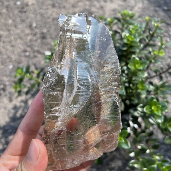 Reverse side with curved growth steps and a clear smoky body