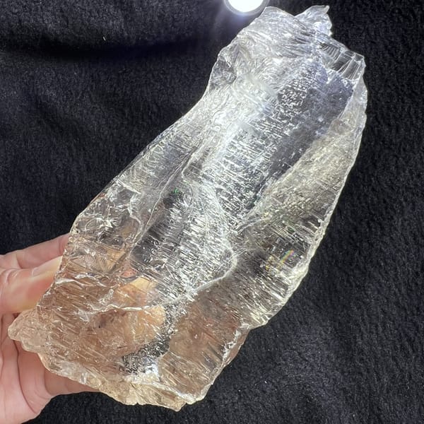 Torch backlighting through the crystal on dark cloth showing inner texture