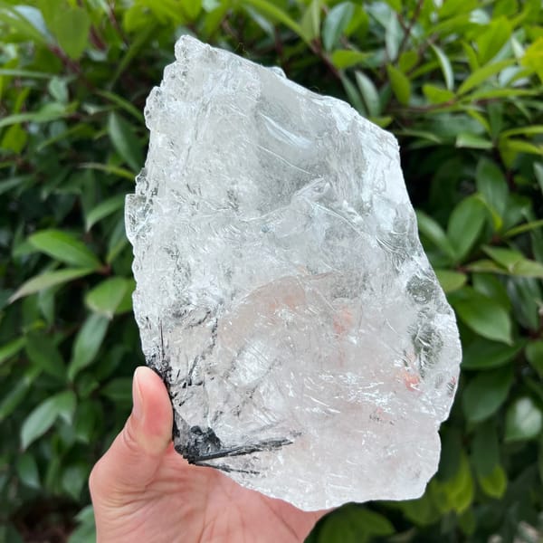 Large clear quartz block with black tourmaline at the lower edge