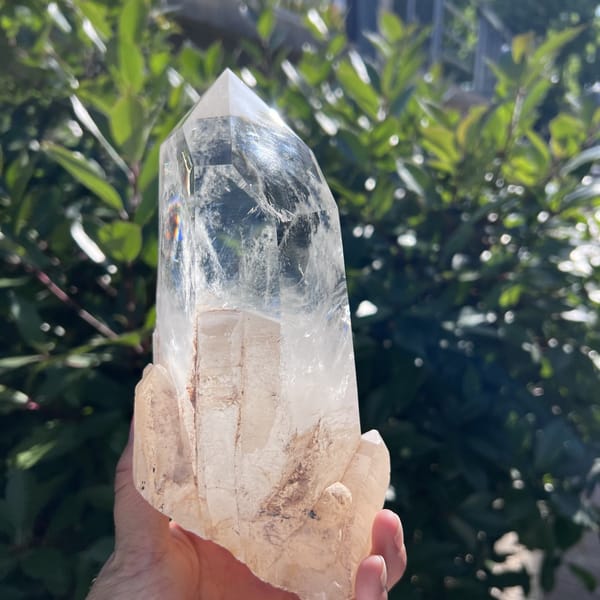Base of small natural crystals beneath the clear quartz point