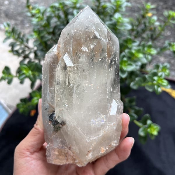 Clear quartz point with a smaller crystal and tourmaline beside it
