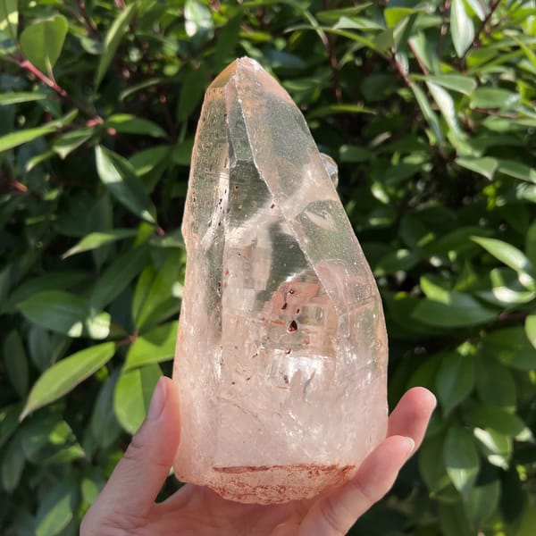 Narrow side of the clear quartz crystal with internal fractures and clear tip