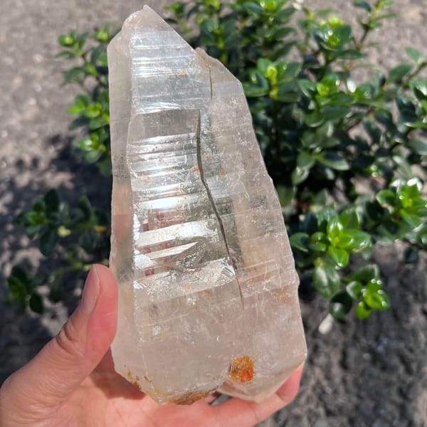 Himalayan clear quartz crystal held up with striking horizontal striations