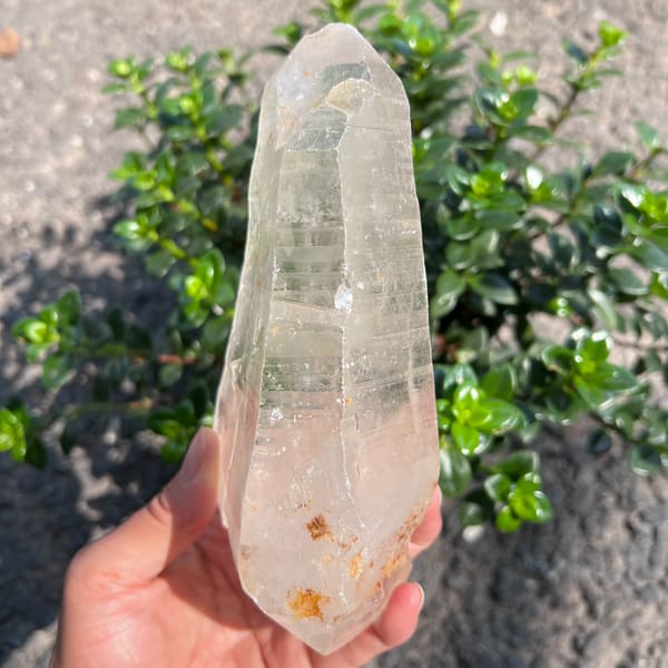 Narrow view of the clear quartz crystal with orange specks near its base