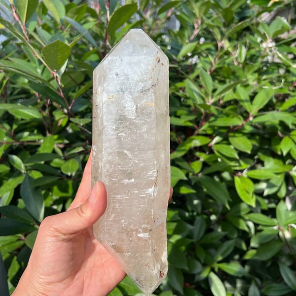 Long double-terminated clear quartz crystal from Madagascar held upright