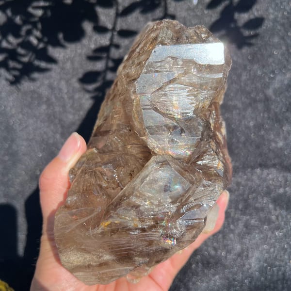 Side of the smoky quartz with a large mirror-like window and etched ripples