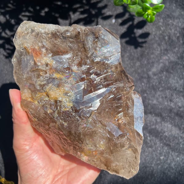 Smoky quartz from the front with rusty patches and rainbow flashes