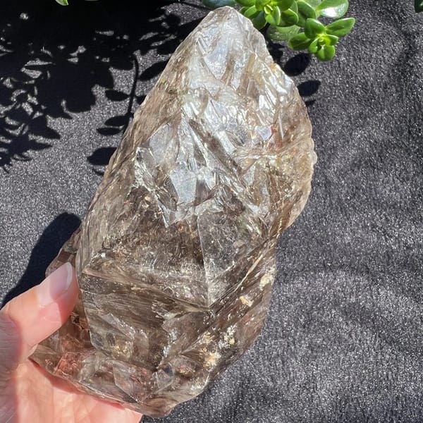 Smoky quartz turned to show the tall termination and etched layers