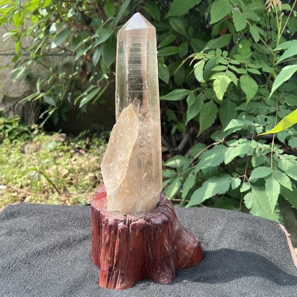 Smoky quartz point on stand showing horizontal striations along the prism