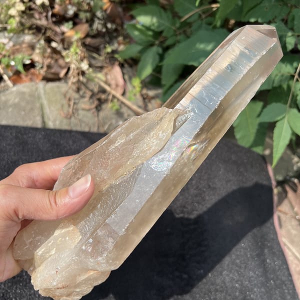 Smoky quartz point held diagonally to show length and striations