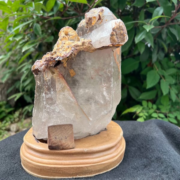 Quartz on stand showing the crusted top and a small wooden shim at the base