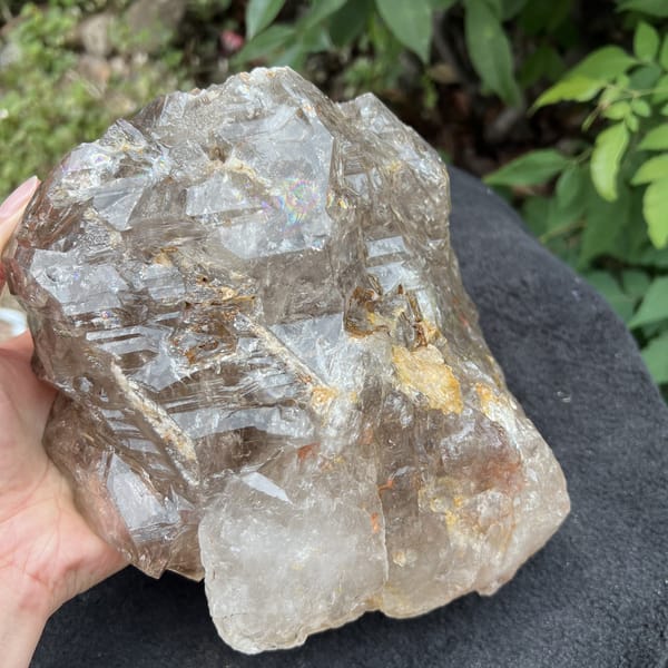 Smoky quartz with layered terraces and pale crystal section at bottom
