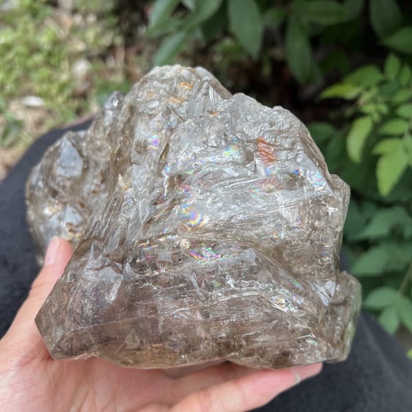 Smoky quartz with rainbow glints across its terraced face