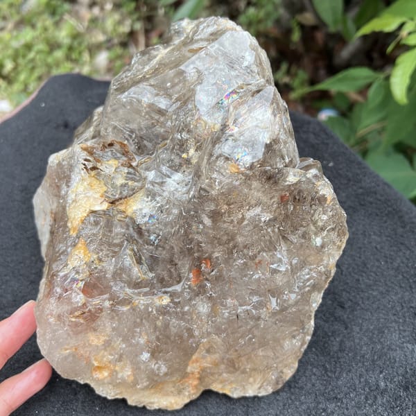 Smoky quartz with golden-cream inclusions along its lower faces