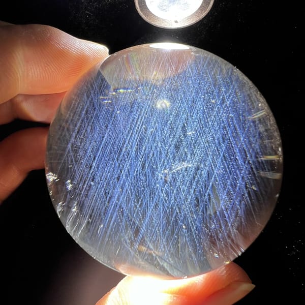 Torchlit sphere filled with fine blue needles like feathers