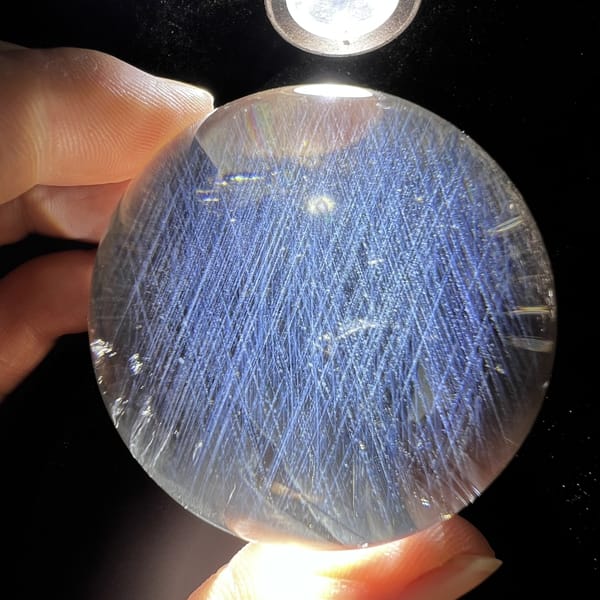 Sphere under focused light with blue needles from top to bottom
