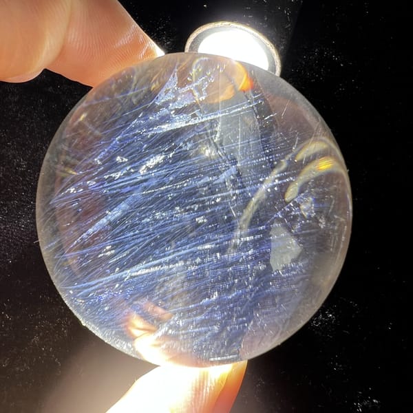 Blue needle sphere showing streaks and small sparkling inclusions