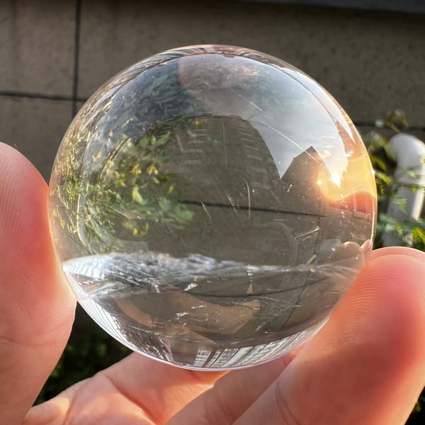 Clear quartz sphere outdoors with a faint inner plane near the base