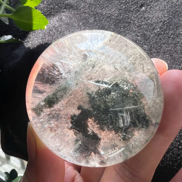 Green phantom sphere with peach tones and fine white veils