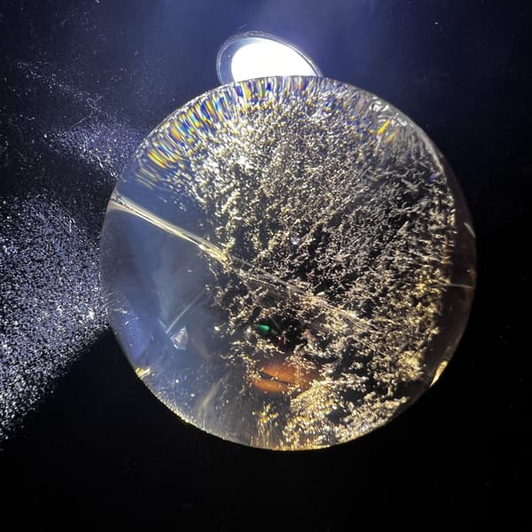 Torchlit smoky sphere showing sparkling golden inclusions across one side