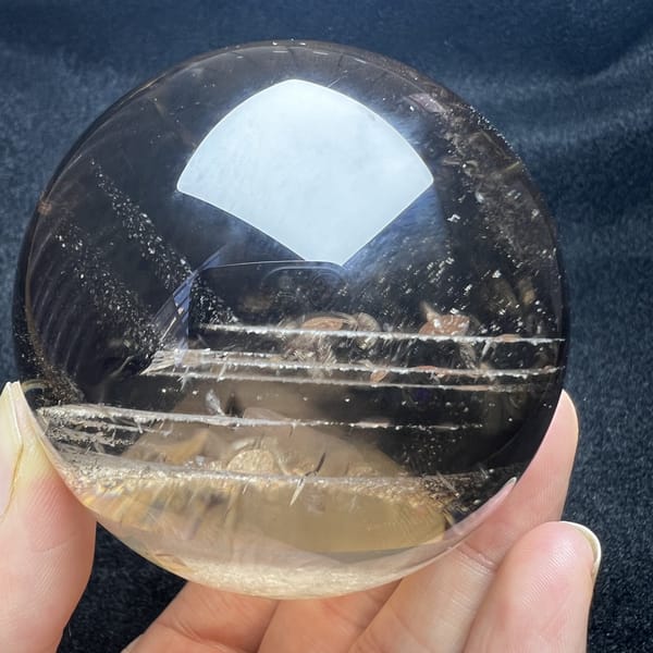 Smoky quartz sphere with deep grey-brown colour and phantom lines