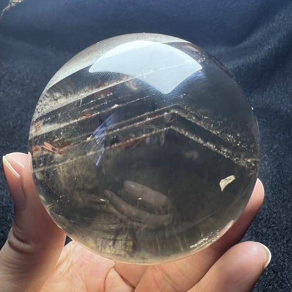 Smoky quartz sphere with a sharp white phantom chevron