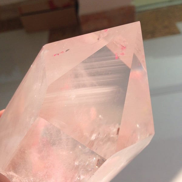 Large faces of the quartz point catching warm light with faint white lines